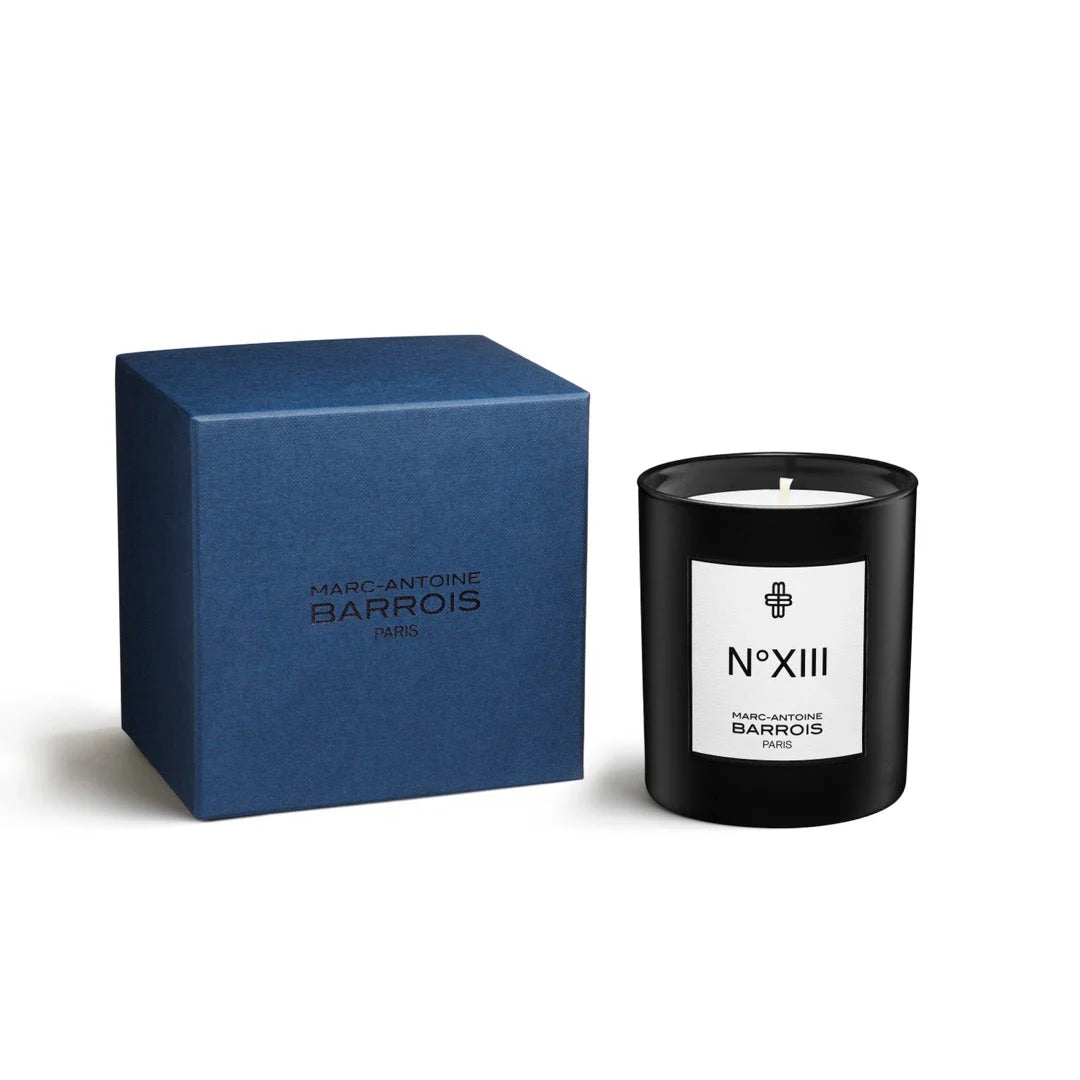 Black candle with white label and blue box on a white background, featuring Marc-Antoine Barrois branding.